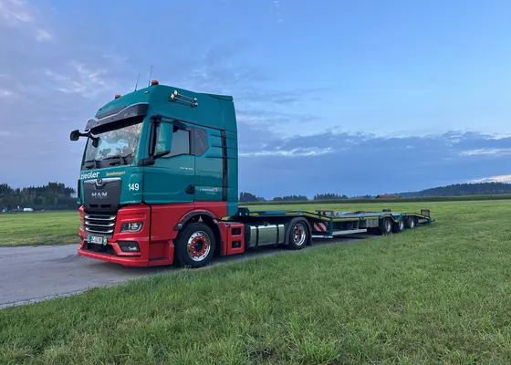 Sattelzug mit Tieflader im Grünen